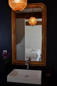 un bagno con specchio, lavandino e letto di Chambre d'hôte au Domaine Terre de Chênes a Saint-Paul-de-Baïse