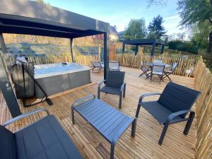 a wooden deck with chairs and a hot tub at Domaine du Gros Chêne - terrasses avec jacuzzis privatifs in Ablon