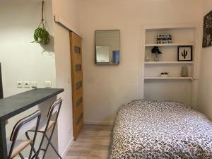 a small bedroom with a bed and a desk and a mirror at CosyRouen Gare in Rouen +92 photos