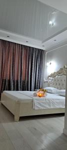 um quarto com uma grande cama branca num quarto em Отличная квартира в центре Алматы, жилой комплекс Ush Qonyr em Almaty