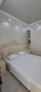 um quarto branco com uma grande cama branca em Отличная квартира в центре Алматы, жилой комплекс Ush Qonyr em Almaty