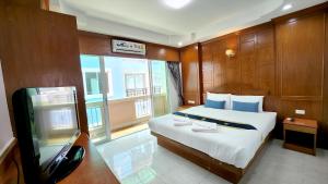 a bedroom with a bed and a tv in it at Chalita House in Patong Beach