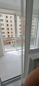uma grande janela com vista para um edifício em Отличная квартира в центре Алматы, жилой комплекс Ush Qonyr em Almaty