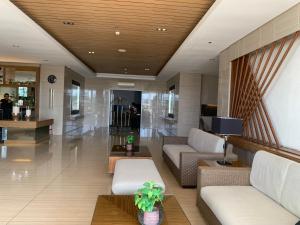 a lobby with couches and a tv in a building at Tagaytay Family Staycation Spacious 2 Unit Condo Sleeps 5 to 7 in Tagaytay