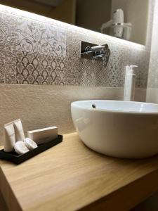 a white sink on a wooden counter in a bathroom at Maison Opéra in Bari