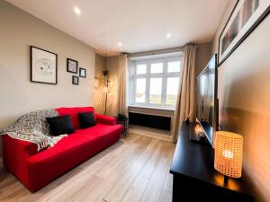 a living room with a red couch and a window at Stylish 2 Bed Apt - Watford Gen Hospital - Watford FC - Professionals & Contractors Welcome in Watford