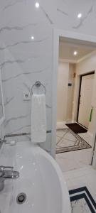 uma casa de banho branca com um WC e uma toalha em Отличная квартира в центре Алматы, жилой комплекс Ush Qonyr em Almaty