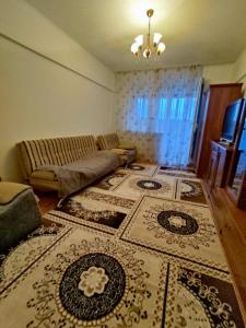 een woonkamer met een bank en een tapijt bij Xata 1+2 in Alma-Ata