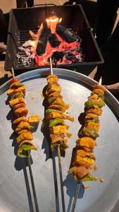 a bunch of skewers of food on a metal plate at Sara green Valley Farm in Mahabaleshwar