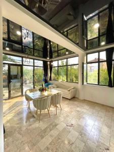 dream villa في تبليسي: غرفة معيشة مع طاولة وبعض النوافذ