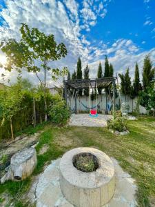 dream villa في تبليسي: حديقة بها حفرة نار في العشب