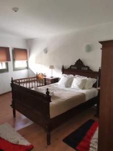 a bedroom with a large wooden bed with white pillows at Casa D'o Canto in Vinhais