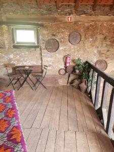 a room with a wooden floor and a table and a bench at Casa D'o Canto in Vinhais