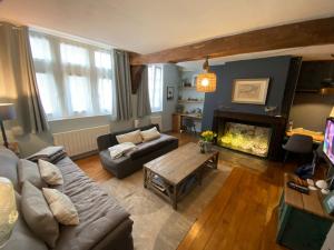 uma sala de estar com um sofá e uma lareira em La Cabane du Pecheur em Honfleur
