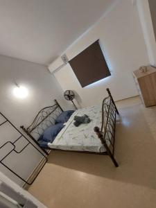 Un dormitorio con una cama con almohadas azules y una ventana en Maison Bel bonjou, en Le Marin