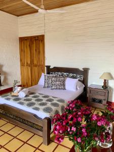- une chambre avec un lit fleuri à l'étage dans l'établissement Rancho Saman, à Pereira