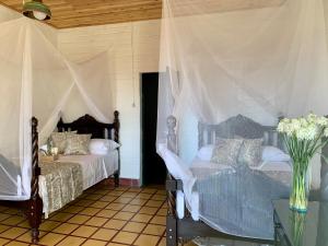 a bedroom with two beds and a table with a vase of flowers at Rancho Saman in Pereira