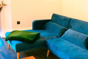 a blue couch with a green pillow on it at Stunning flat in Brighton & Hove - Central luxury. in Brighton & Hove