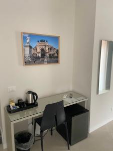 a desk with a chair and a picture on the wall at Maqueda Suites in Palermo