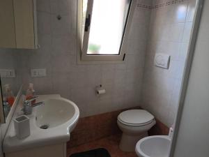a bathroom with a sink and a toilet and a window at Casa Teresina in Cannole +10 photos