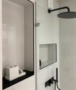 a mirror on the wall of a bathroom with a sink at Studio flat in the heart of St. Johns Wood in London