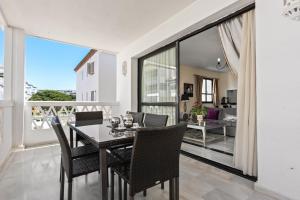 a dining room with a table and chairs on a balcony at Beachside Luxury Apartment in Puerto Banus - Club Playas del Duque in Marbella
