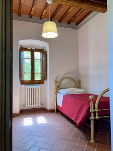 1 dormitorio con cama y ventana en Agriturismo Podere Filicaia, en San Giovanni Valdarno