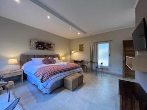 a bedroom with a bed and a table and chairs at Los Plátanos cabañas & suites in Moreno