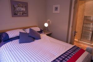 a bedroom with a bed with blue pillows on it at No 1 Kennington Court in Llandudno