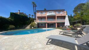 a house with a swimming pool in front of a house at Maison Prakash in Mougins