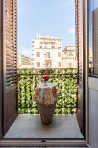 Un jarrón grande sentado en un balcón con ventana en Binario 91 Rooms, en Palermo