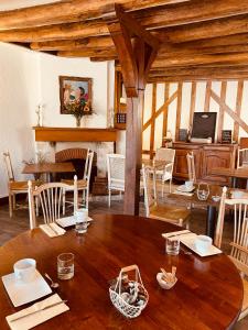 um quarto amplo com uma mesa de madeira e cadeiras em Hotel de la Sologne em Beaugency