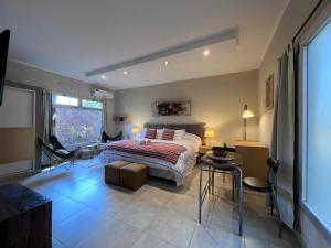 a bedroom with a bed and a table and chairs at Los Plátanos cabañas & suites in Moreno