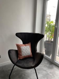 a black chair with a pillow on it next to a window at Casa800 in Capri