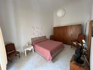 a bedroom with a bed and a chair and a tv at Piero's Home in Castellana Grotte