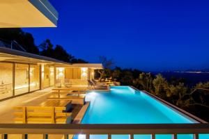 a villa with a swimming pool at night at Villa Ble in Katávolos