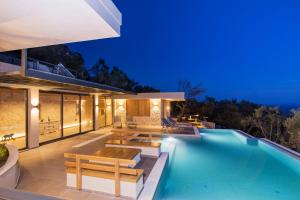 a villa with a swimming pool at night at Villa Ble in Katávolos