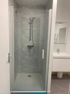 a shower in a bathroom with a sink at L'appart du bourg - 4 chambres lits doubles - sur 2 niveaux - 2 salles de bain - séjour avec espace salon et cuisine équipée ouverte sur le séjour - in Beaumont-Hague
