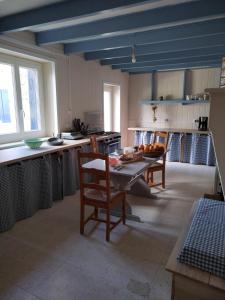 Il comprend une cuisine dotée de plafonds bleus, d'une table et de chaises. dans l'établissement Gîte du Gardoir, à Boresse-et-Martron