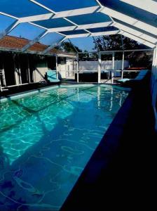 uma piscina com água azul e um telhado branco em Tiki bar house with pool -self checkin- em Bradenton