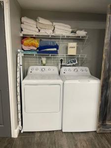 duas máquinas de lavar roupa numa lavandaria com toalhas em Tiki bar house with pool -self checkin- em Bradenton