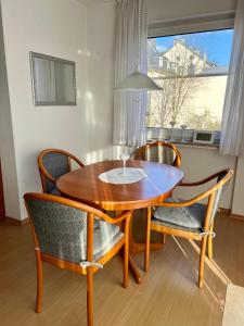een houten eettafel met stoelen en een raam bij Lichtdurchflutete große Wohnung in Schwelm