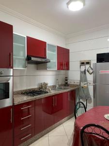 una cocina con armarios rojos y electrodomésticos de acero inoxidable en Résidence ASSAFA 3 AGADIR Familiale, en Agadir
