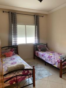 1 dormitorio con 2 camas y ventana en Résidence ASSAFA 3 AGADIR Familiale, en Agadir