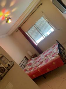 ein kleines Schlafzimmer mit einem Bett und einem Fenster in der Unterkunft Résidence ASSAFA 3 AGADIR Familiale in Agadir + 5 Fotos