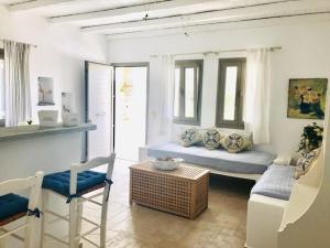 ein Wohnzimmer mit einem Sofa und einem Stuhl in der Unterkunft La Bastide in Skyros