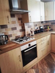 a kitchen with a stove top oven and wooden cabinets at Sweet Dreams of Bournemouth in Bournemouth