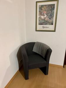een stoel in een kamer met een foto aan de muur bij Lichtdurchflutete große Wohnung in Schwelm