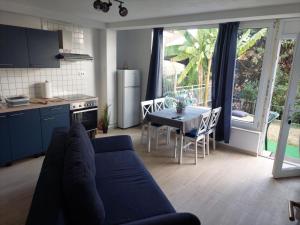 a living room with a couch and a kitchen with a table at APARTMENT RAFAELLO in Portorož