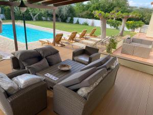 a patio with a table and chairs and a pool at Relaxing Villa with Swimming Pool and Garden in Áyios Yeóryios